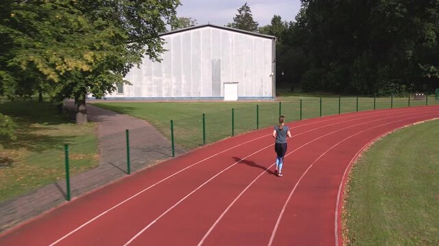 Woman running on track during outdoor workout