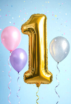 Golden foil number one balloon with colorful balloons and confetti celebration setup