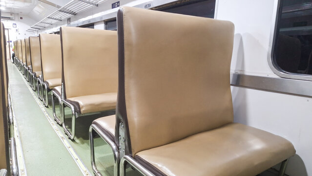 Empty Brown Leather Seats Inside a Classic Passenger Train Carriage for Public Transportation and Commuting Travel