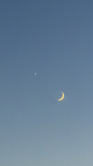 Vertical photo of crescent moon and bright star conjunction in twilight blue sky © Екатерина Переславце
