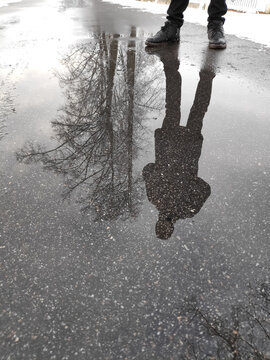 Vertical view of an anonymous stranger double on a damp footway for existential concepts