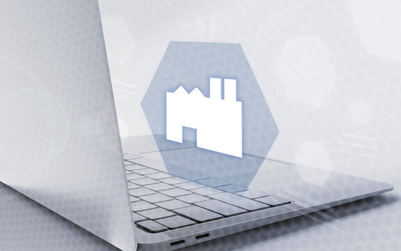 Una computadora port&aacute;til abierta con un icono digital de f&aacute;brica flotando en la pantalla, representando software de gesti&oacute;n industrial y tecnolog&iacute;a moderna.