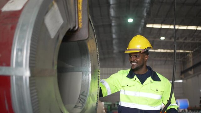 Factory worker examines galvanized steel coil