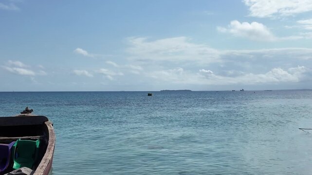 Wooden boat floating on turquoise ocean near Zanzibar sandbank