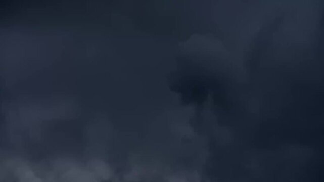 Dark storm clouds rolling across the open sky at dusk
