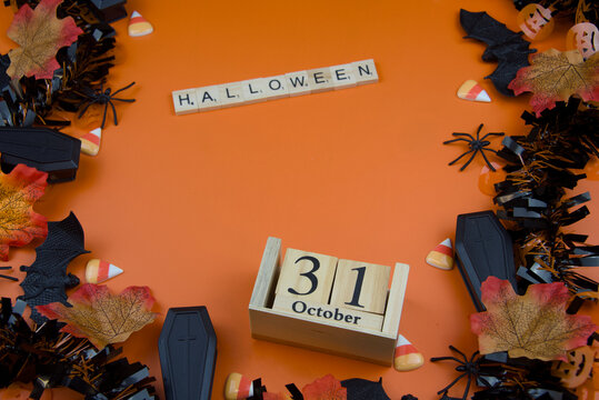 Semaphore, South Australia - July 22 2026: halloween decorations framing an orange background with a wooden calendar and halloween tiles