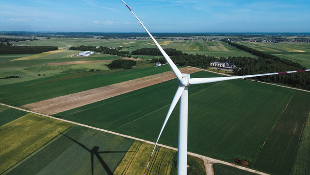 Wind turbine in expansive fields under a clear sky