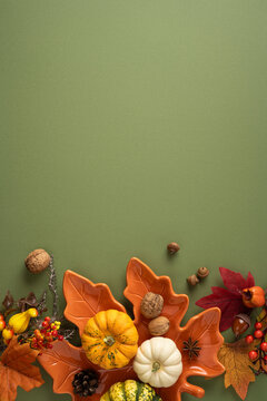 Autumn thanksgiving vertical arrangement with small pumpkin gourd leaves nuts and rustic orange ceramic dish