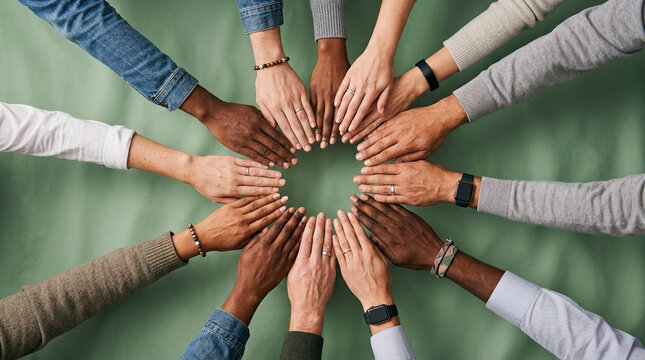Diverse group of people showing unity and teamwork with hands clasped together