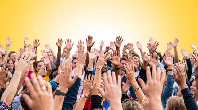 Diverse group of people raising hands together in celebration against yellow background