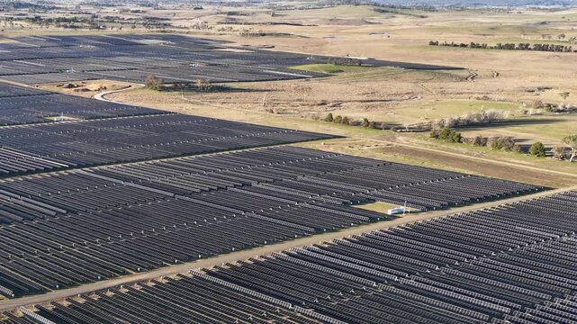 Aerial View of Large Scale Solar Farm Infrastructure in Rural Landscape