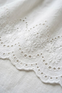 Close-up of delicate white eyelet lace fabric texture.