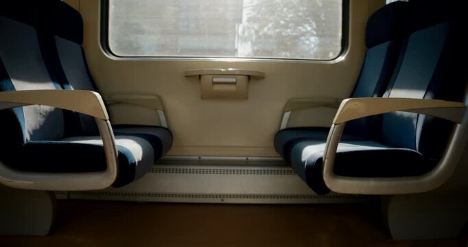 Silhouette of a person walking into a quiet train carriage to take a seat. Concept of rail travel, passenger commuting, public transportation, and daily journeys. 4K.