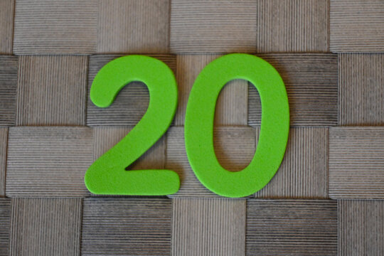 Green number 20 on woven wooden surface