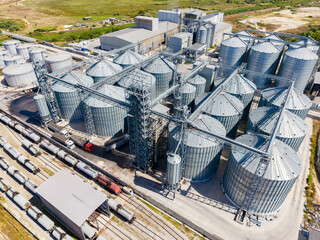 Grain storage facility located near rail tracks with numerous silos and buildings on a sunny day © DSMT