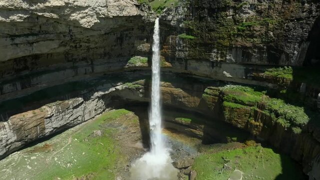Aerial footage of Tobot Waterfall dropping from a high cliff into a deep rocky canyon on the Khunzakh Plateau, Republic of Dagestan, Russia