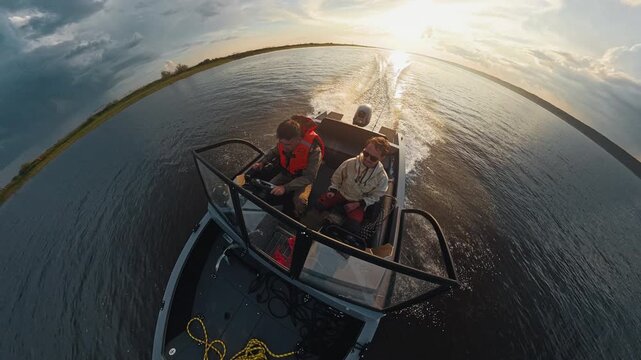 Two fishermen explore the river on the speed motor boat