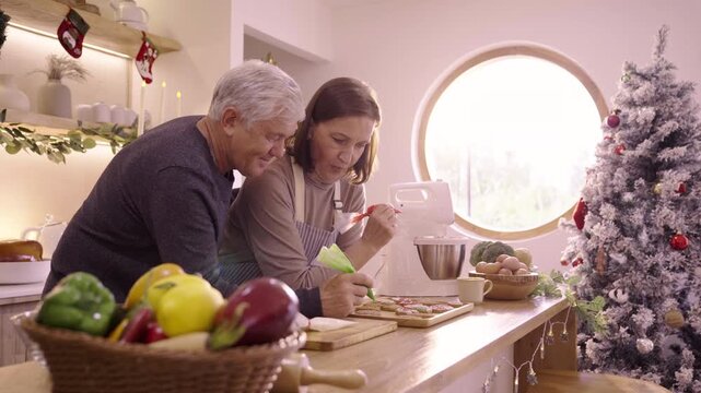 Caucasian family decorating gingerbread cookies in kitchen at home site