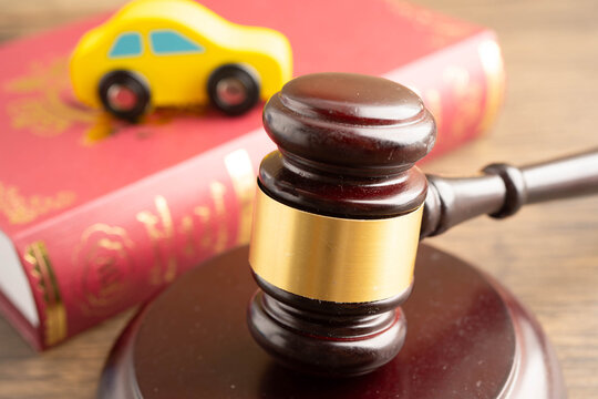 Car accident lawsuit and insurance, Judge hammer with car model.