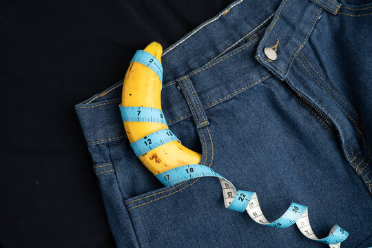 Banana with measuring tape on jean trousers, penis health.