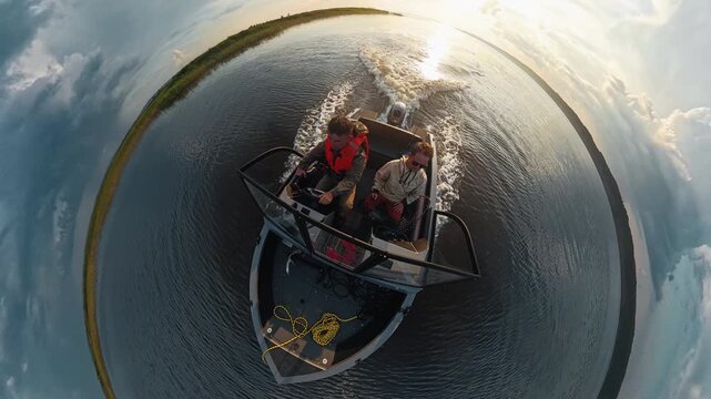 Two fishermen explore the river on the speed motor boat