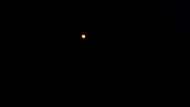 Glowing orange orb flickers and rapidly recedes into darkness, creating abstract fiery light movement against a black background in a minimalist digital animation