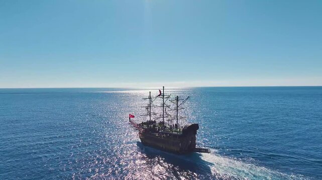 Aerial Video Vintage Pirate Ship Approaching A Coastal Harbor, Sailing Through The Deep Blue Sea On A Sunny Day