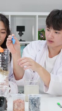 Teenage Students Conducting Water Filtration Science Experiment in Classroom Laboratory