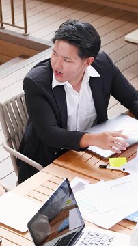 Asian Businessman Reacting Emphatically During Outdoor Meeting