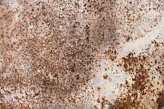 Weathered rusty metal surface with heavy corrosion spots and mottled patina. High-detail close-up texture ideal for industrial, vintage or grunge backgrounds, designs, and surface damage concepts