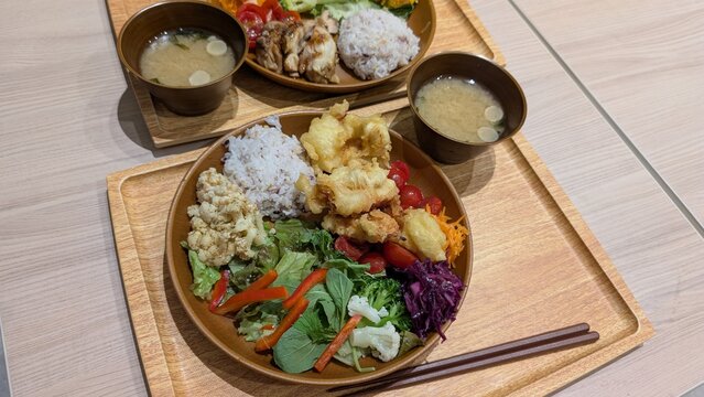 Two healthy Japanese lunch sets with chicken, multigrain rice, vegetables and miso soup
