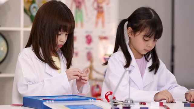Two Schoolgirls in Lab Coats Conducting Science Experiments in Classroom