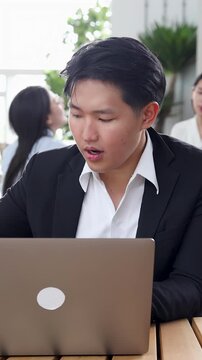 Asian Businessman in Black Suit Working on Laptop at Modern Office