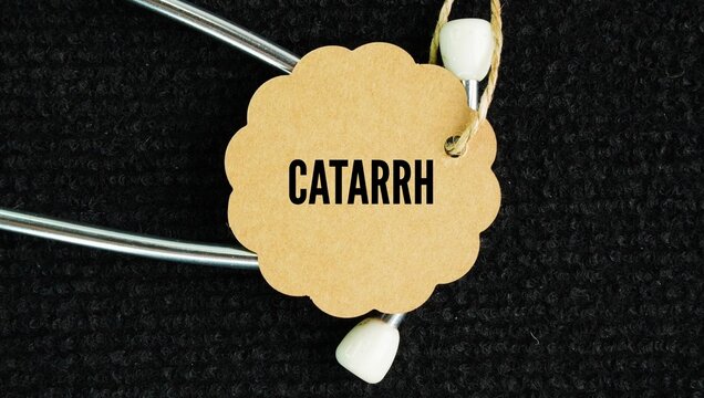 Stethoscope and paper tag with the word Catarrh is the excessive buildup of mucus in the nose, throat, or sinuses caused by the inflammation of mucous membranes.