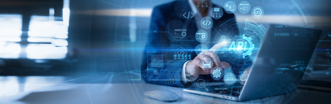 API technology concept with software developer using laptop and touching virtual API icons, interactive interface, real-time analytics, secure data, innovation and connected business workflow.