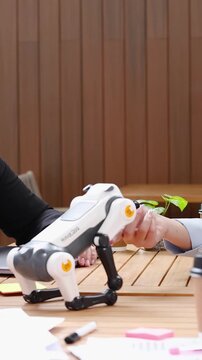 Business Colleagues Handshaking Behind Robotic Dog on Office Meeting Table