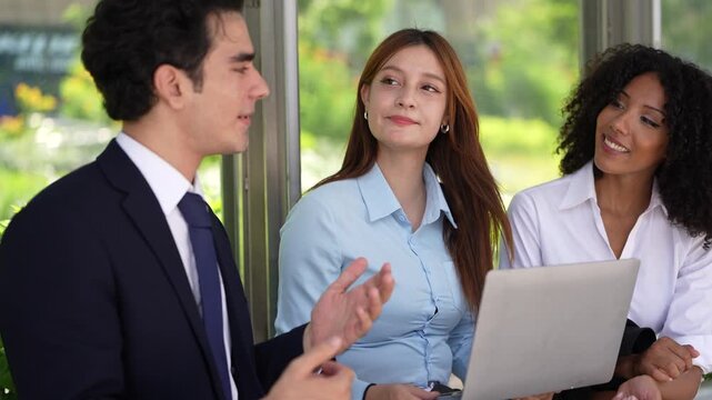 Close bench portrait of a businessman explaining an idea with his hands to two attentive colleagues, a warm image of mentoring and knowledge sharing in a young team