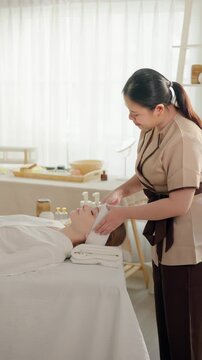 Beautiful woman getting head and facial massage treatment at beauty spa. 