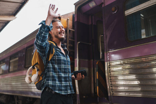 Young traveler waving goodbye from train platform