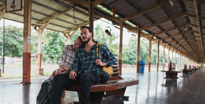 Couple of backpackers waiting for a train journey