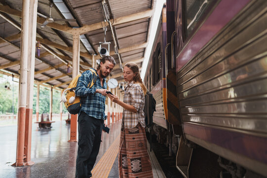 Backpackers using smartphone for navigation at train station