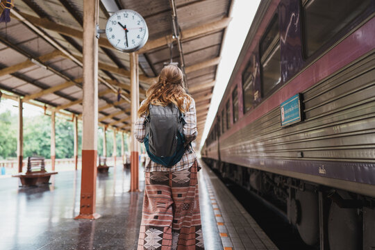 Woman with backpack waiting for train departure