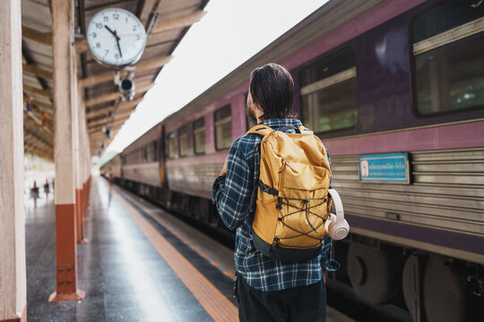 Traveler with backpack waiting for train at station platform