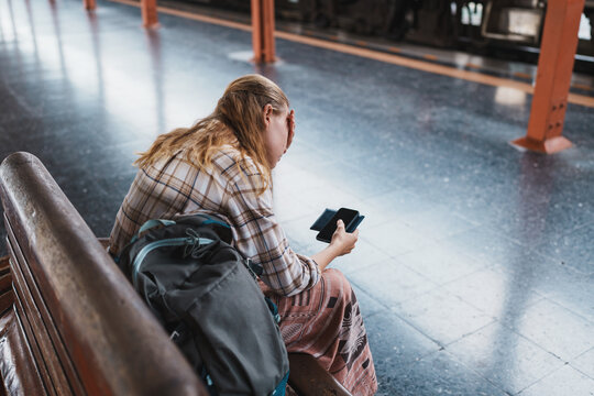 Woman sitting waiting at train station platform