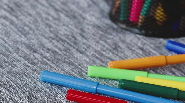 Colorful markers thrown onto a textured surface for a creative art project during afternoon leisure time