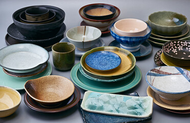 Collection of colorful ceramic bowls, plates, cups and saucers featuring varied glazes, textures...