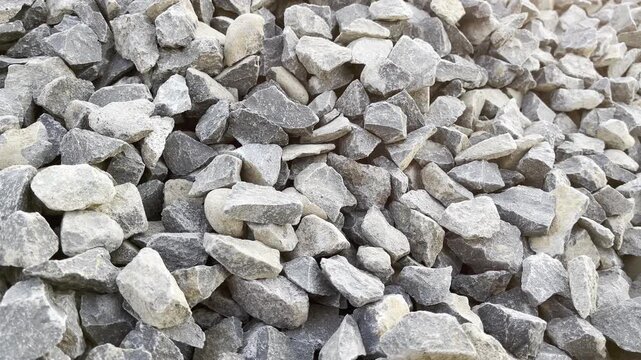 Piles of raw mixed gravel stones background texture