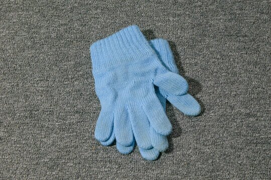 Blue gloves placed on gray fabric surface in indoor setting for various tasks