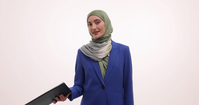 Female executive in hijab presents statistical information to colleagues during business meeting. Businesswoman holds document on white background