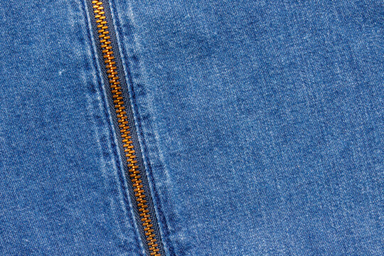 Blue denim fabric texture background with metal zipper